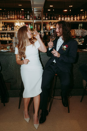 An unconventional wedding photo of a wedding couple at a bar before their wedding at Standesamt Mandlstraße